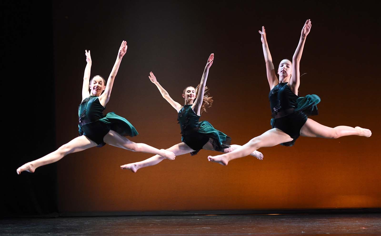 Young dancers leaping on stage